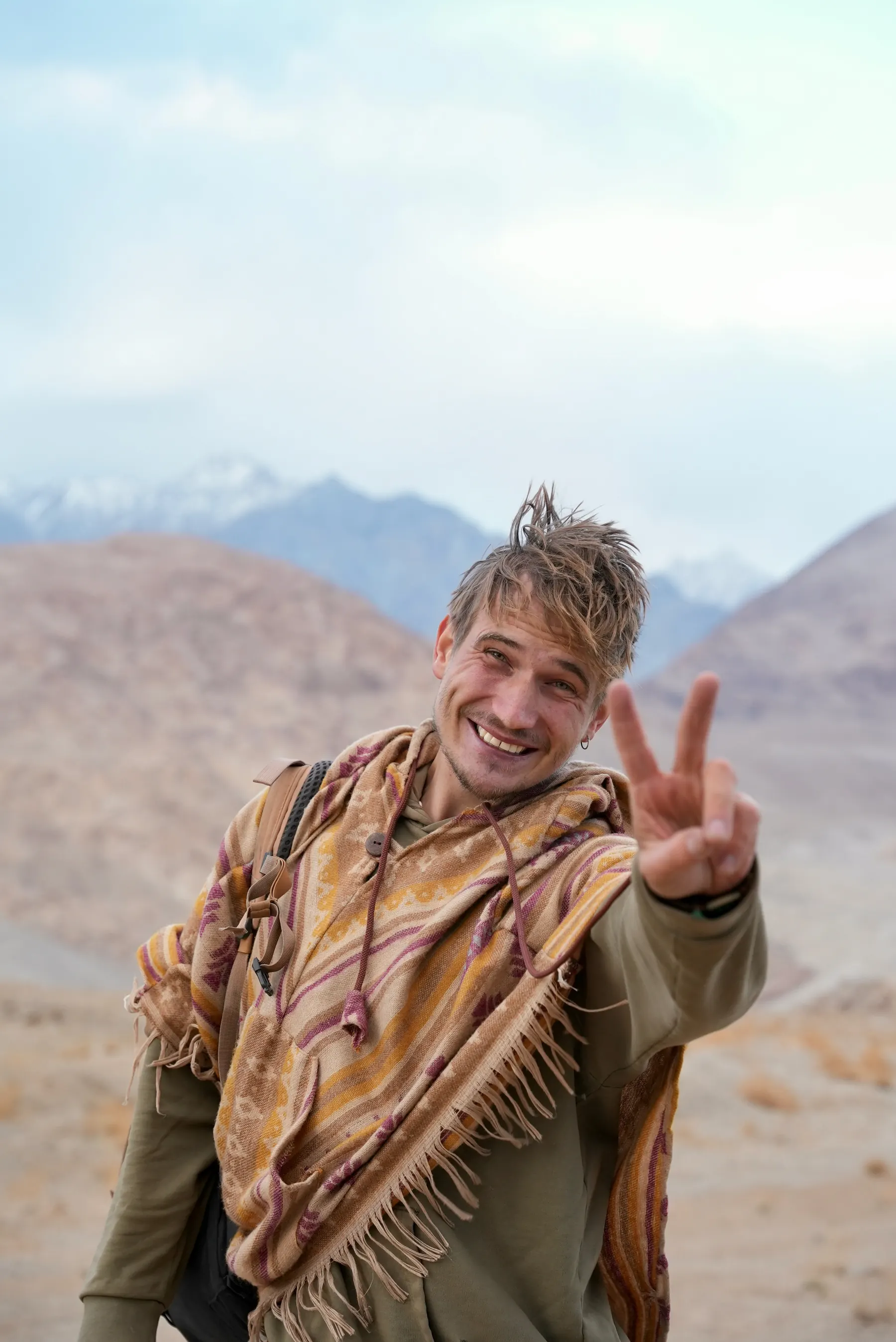 Josua Wirth mit Poncho und Rucksack in den Bergen Nepals