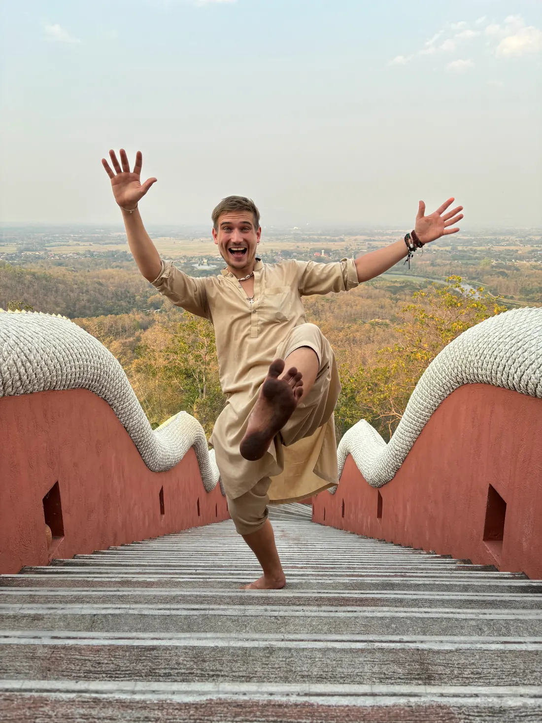 Josua springt auf einer Tempeltreppe in Nordthailand